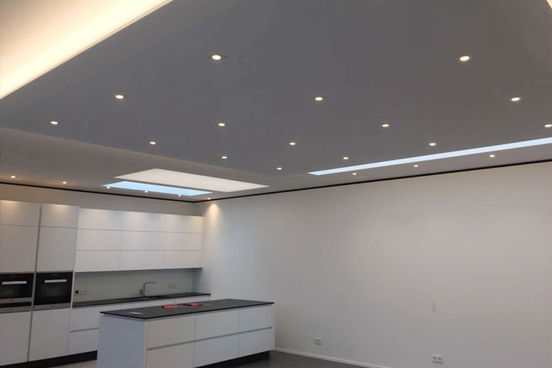 Galerie Spanndecken Küche weiss matt mit vielen Einbaustrahlern und Lichtdecke über dem Herd
